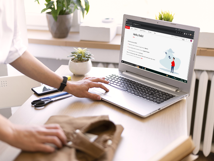 Persona usando una laptop con el Getnet Portal en pantalla. Sobre la mesa hay un teléfono móvil, tijeras, bolígrafo y una prenda doblada.