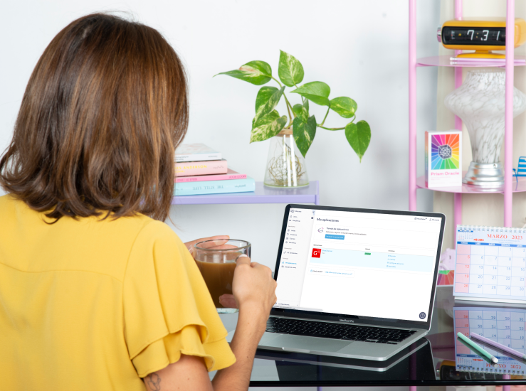 Persona sentada frente a una laptop que muestra a Getnet como opción de gestión de ventas, sosteniendo una taza en la mano.